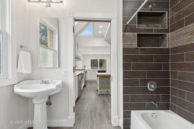 bathroom with shower / bathtub combination, wood finished floors, and baseboards