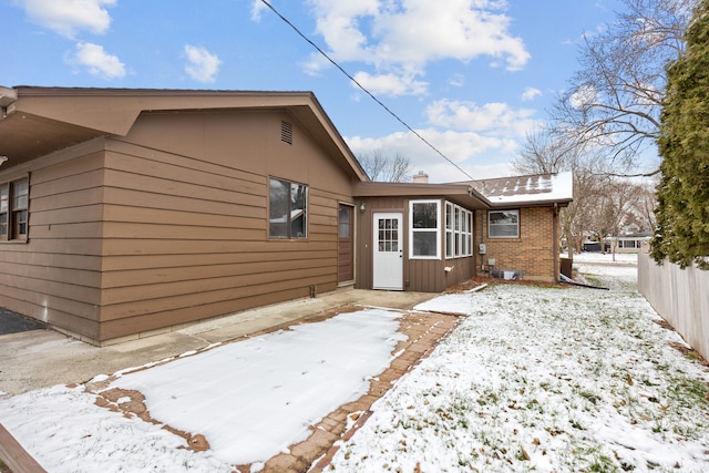 snow covered property with a patio