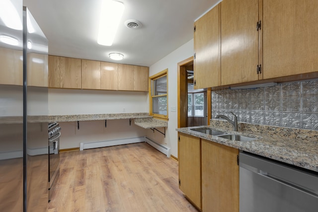 kitchen with stainless steel appliances, backsplash, light stone countertops, sink, and light hardwood / wood-style floors