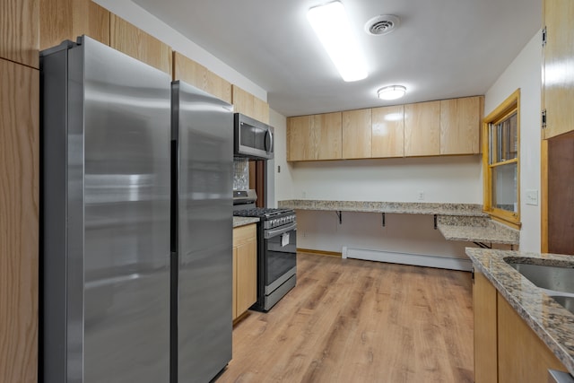 kitchen featuring stainless steel appliances, light wood-type flooring, light brown cabinets, light stone countertops, and a baseboard heating unit