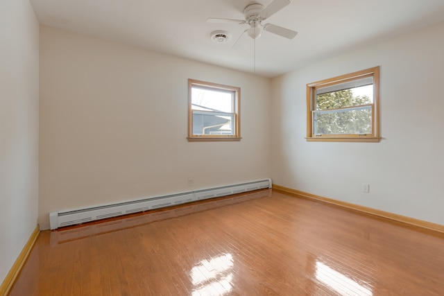 spare room with light hardwood / wood-style flooring, ceiling fan, and a baseboard heating unit