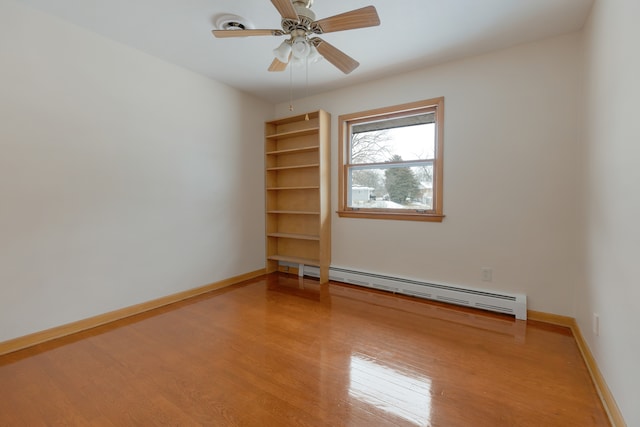 empty room featuring light wood-type flooring, ceiling fan, and a baseboard radiator