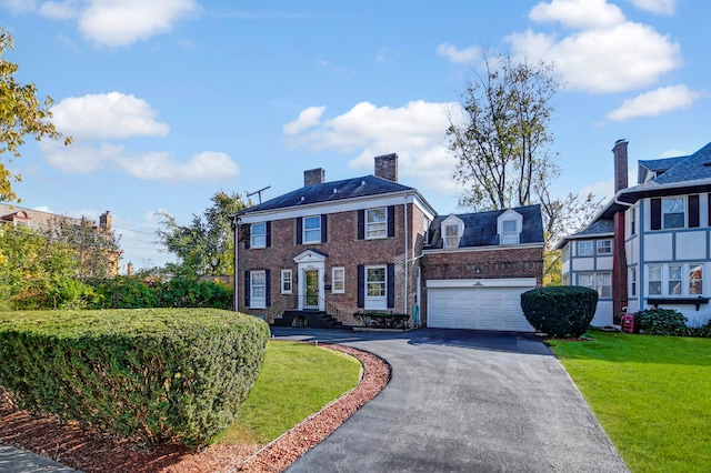 colonial house with a garage and a front lawn