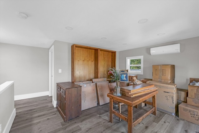 home office featuring hardwood / wood-style flooring and a wall mounted AC