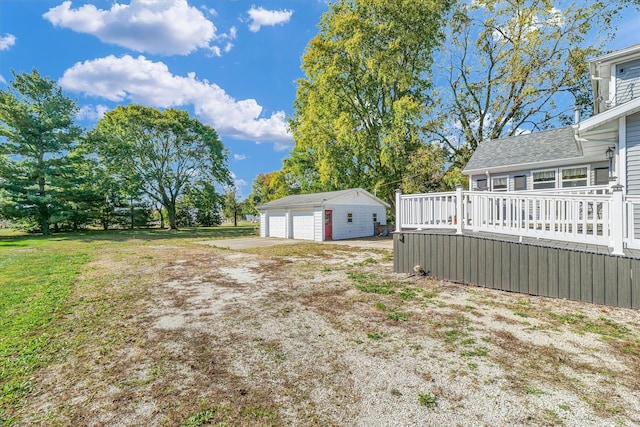 view of yard with a wooden deck, an outdoor structure, and a garage