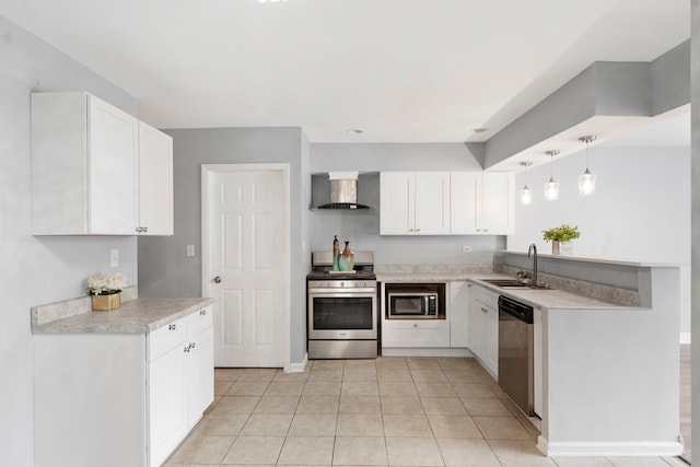 kitchen with wall chimney range hood, sink, appliances with stainless steel finishes, white cabinetry, and decorative light fixtures