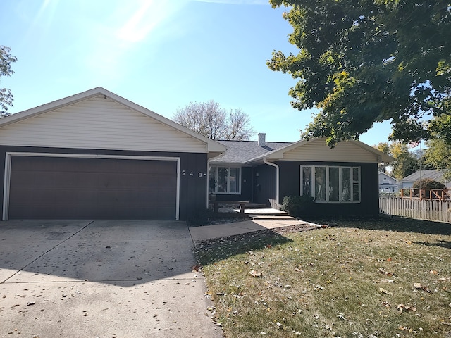 ranch-style house featuring a garage and a front lawn