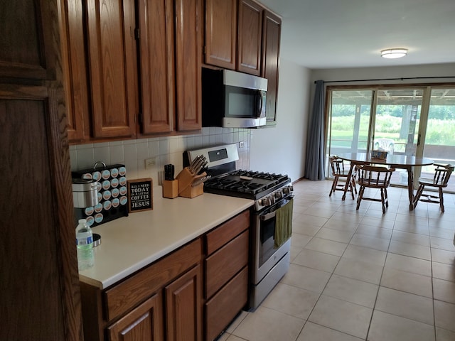 kitchen with decorative backsplash, stainless steel appliances, and light tile patterned floors