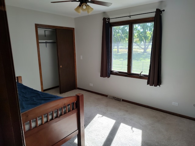 carpeted bedroom featuring a closet and ceiling fan