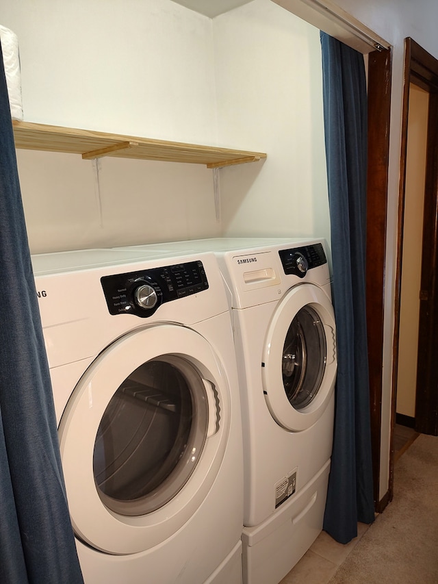 washroom with washer and clothes dryer and light tile patterned floors