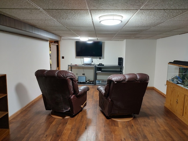 living room with a drop ceiling and dark wood-type flooring