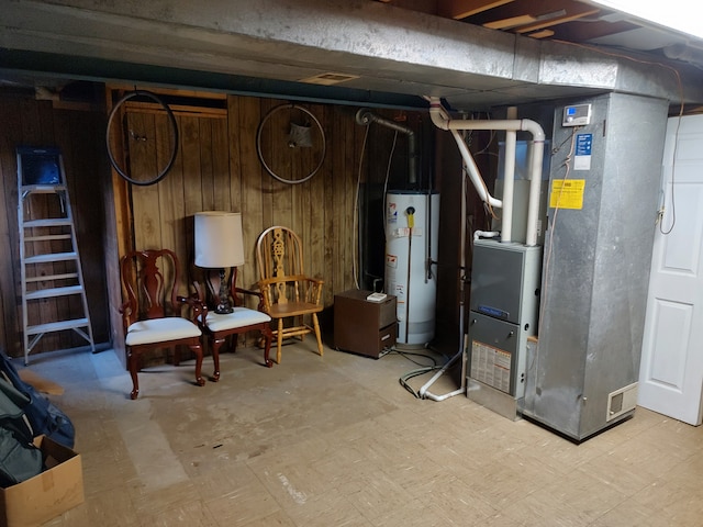 basement featuring wooden walls, heating unit, and gas water heater