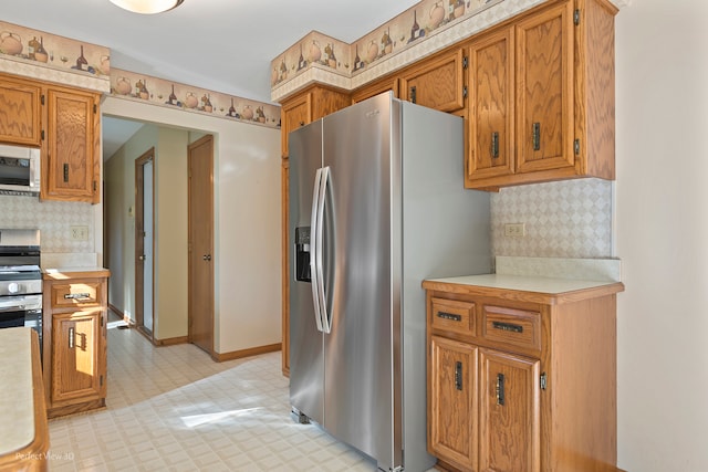 kitchen with appliances with stainless steel finishes and backsplash