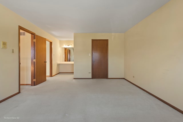 unfurnished room featuring light carpet