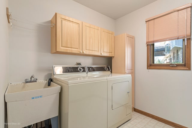 laundry area featuring sink, washing machine and dryer, and cabinets