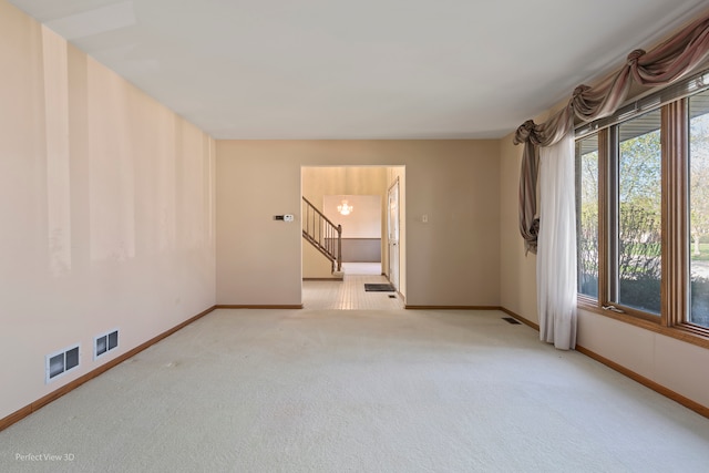 spare room featuring light colored carpet