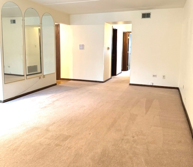 spare room featuring light colored carpet