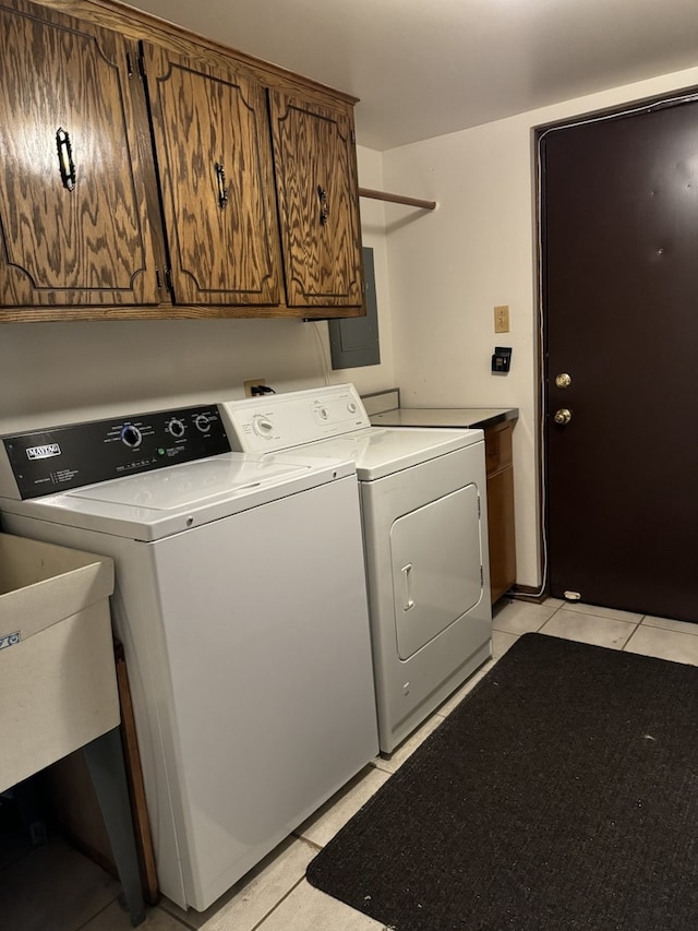 laundry room featuring cabinets, electric panel, washing machine and clothes dryer, and light tile patterned floors