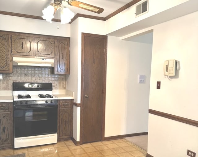 kitchen with crown molding, decorative backsplash, dark brown cabinets, and white range with gas stovetop