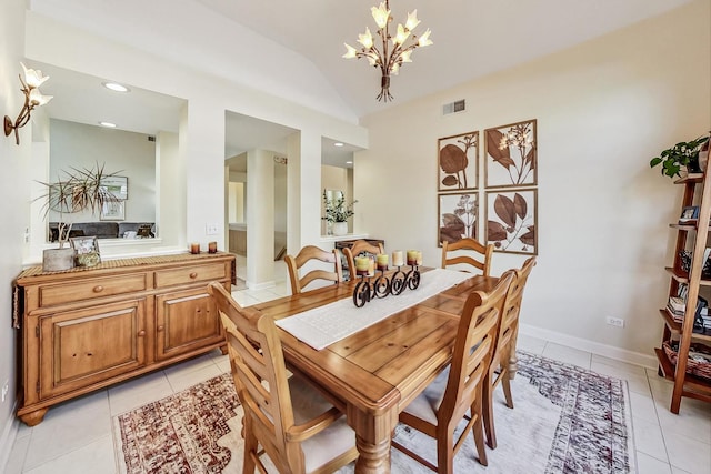 dining space with an inviting chandelier, lofted ceiling, and light tile patterned floors