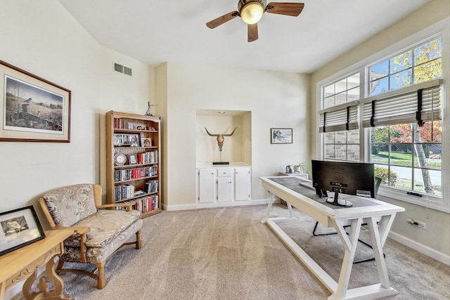 carpeted office space with a healthy amount of sunlight and ceiling fan