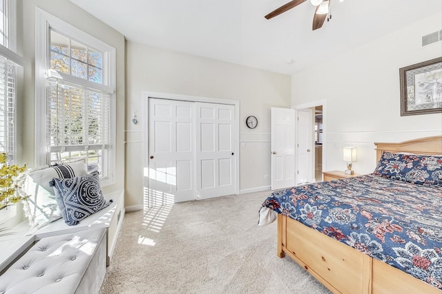 carpeted bedroom with multiple windows, a closet, and ceiling fan