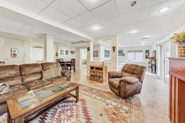 living room featuring a paneled ceiling and light tile patterned floors