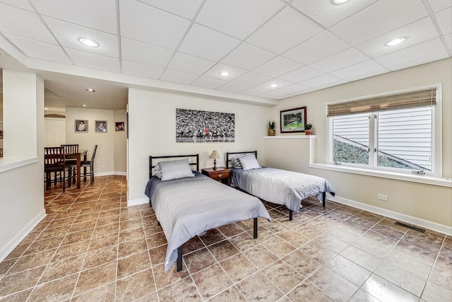 bedroom featuring tile patterned floors and a paneled ceiling