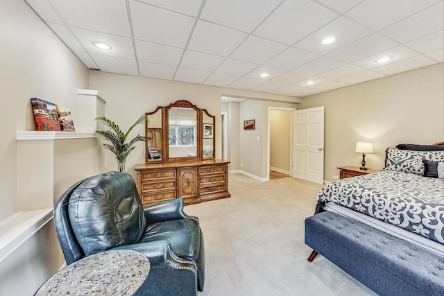 carpeted bedroom featuring a drop ceiling