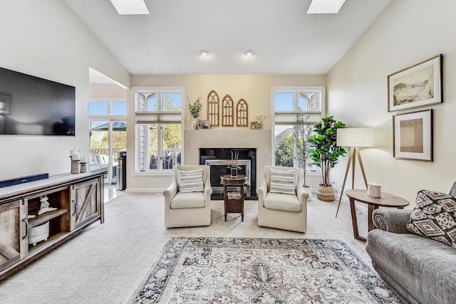 living room featuring light carpet, plenty of natural light, and lofted ceiling with skylight