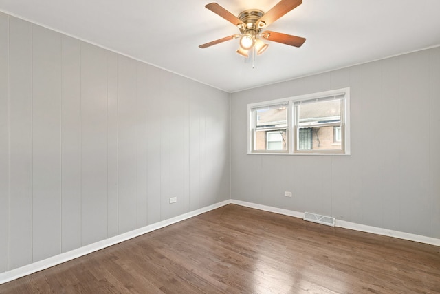 spare room featuring ceiling fan and dark hardwood / wood-style flooring