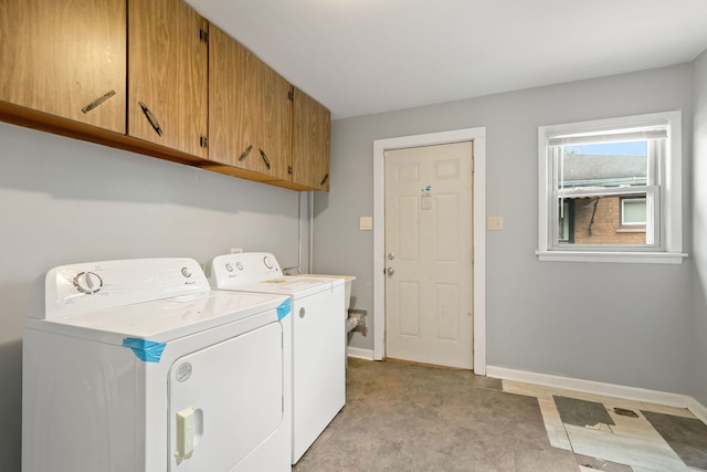 washroom featuring washer and clothes dryer and cabinets