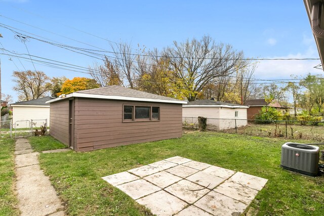 view of yard featuring central AC unit, an outbuilding, and a patio