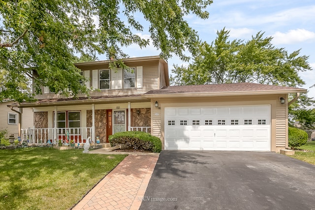 view of front of property with a garage, a front lawn, and a porch