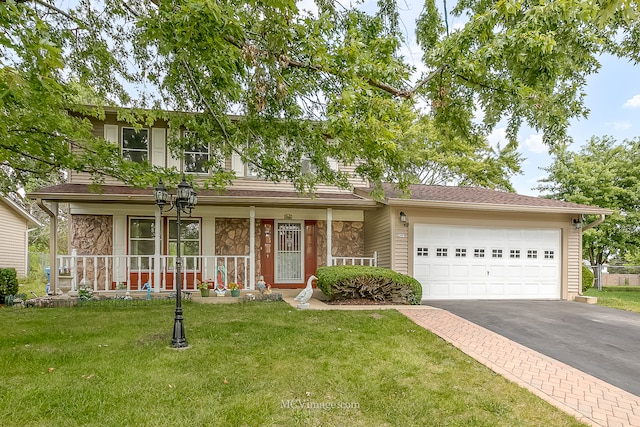 view of front of home with covered porch, a front yard, and a garage