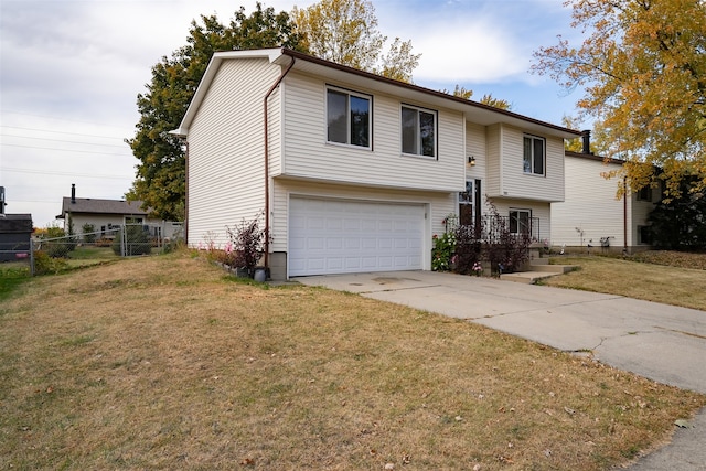 raised ranch featuring a front lawn and a garage