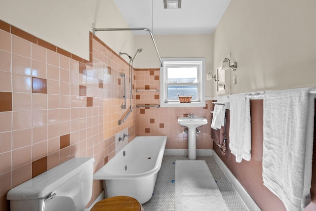 bathroom with tile walls, visible vents, toilet, tub / shower combination, and tile patterned flooring