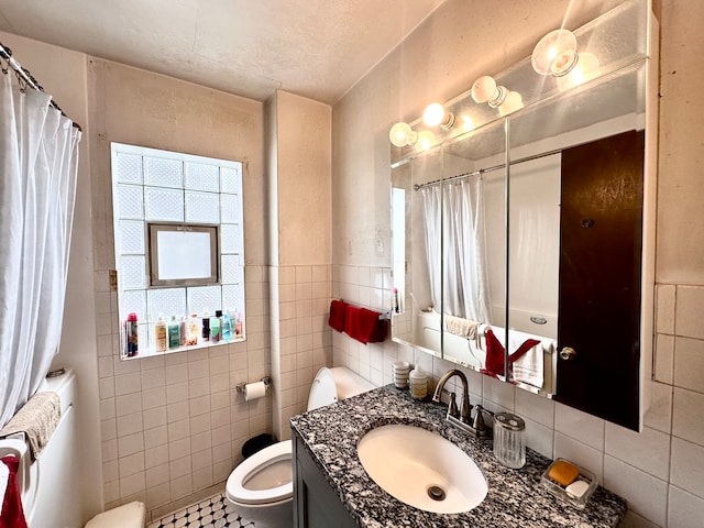 bathroom featuring tile walls, vanity, toilet, and tile patterned floors