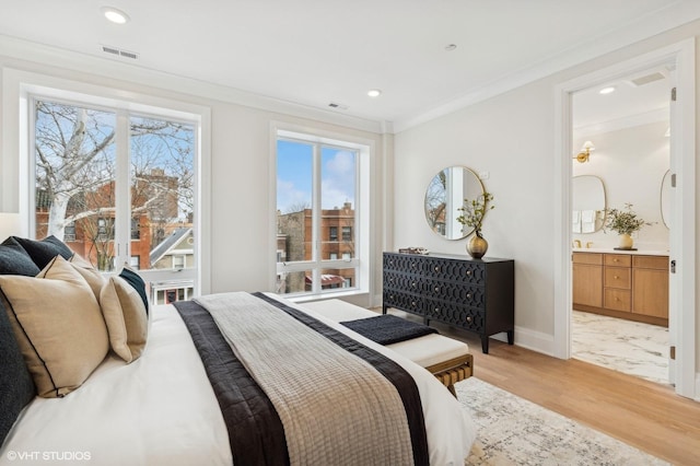 bedroom featuring connected bathroom, crown molding, and hardwood / wood-style flooring