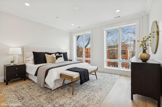 bedroom featuring light wood-type flooring and crown molding