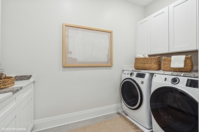 clothes washing area featuring cabinets, independent washer and dryer, and light tile patterned flooring