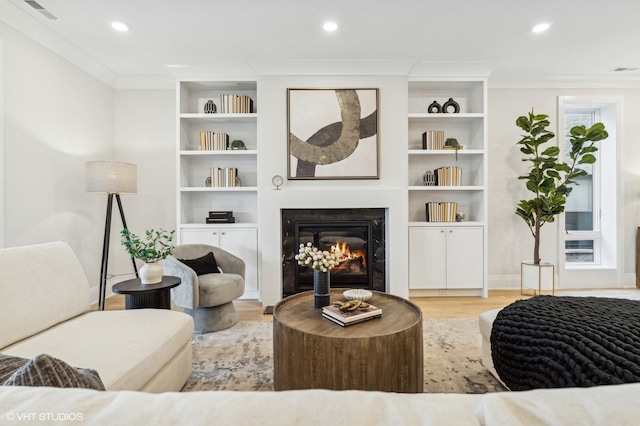 sitting room with light hardwood / wood-style flooring and ornamental molding