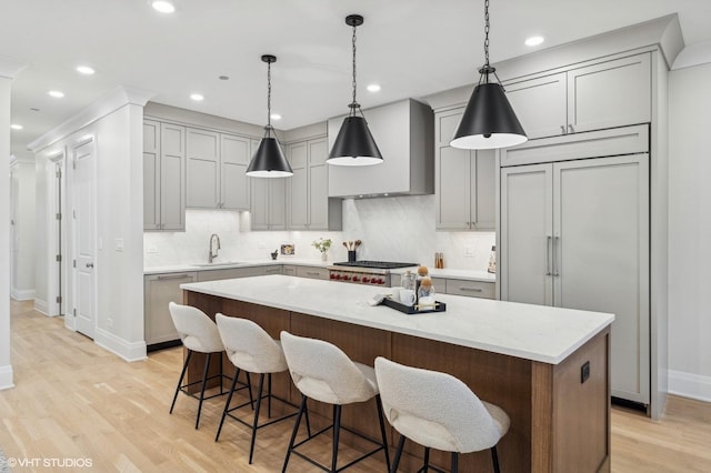 kitchen with light stone countertops, light wood-type flooring, stainless steel appliances, and a kitchen island