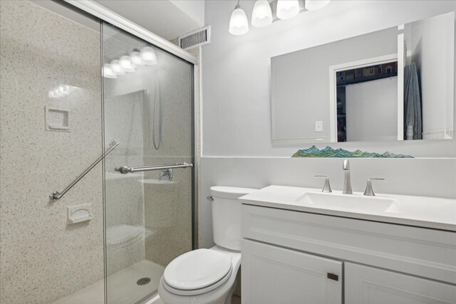 bathroom featuring vanity, toilet, and an enclosed shower