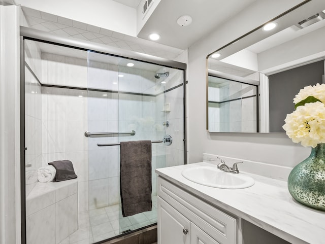 bathroom featuring vanity and a shower with door