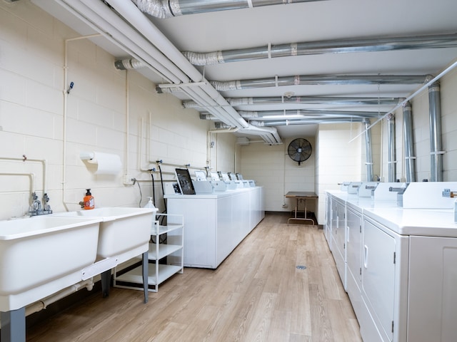 laundry room with tile walls, independent washer and dryer, and light hardwood / wood-style floors