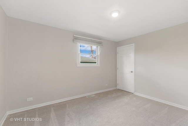 spare room featuring light colored carpet