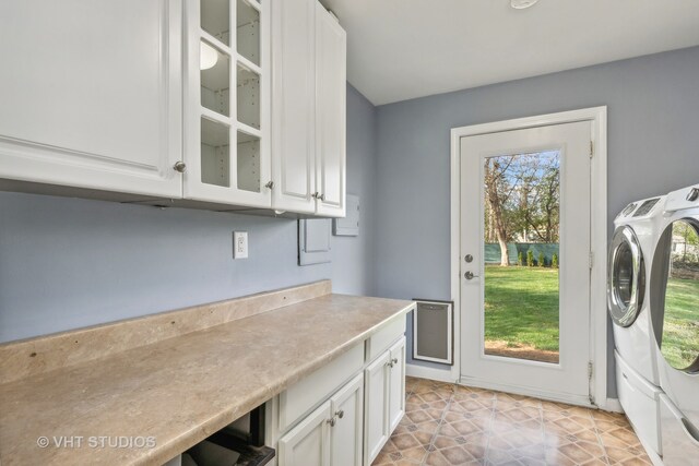 washroom with cabinets and washing machine and clothes dryer