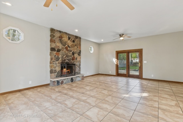 unfurnished living room featuring a fireplace, light tile patterned flooring, and ceiling fan