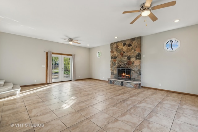 unfurnished living room with light tile patterned flooring, french doors, ceiling fan, and a fireplace